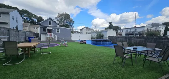 a view of a house with a backyard and chairs