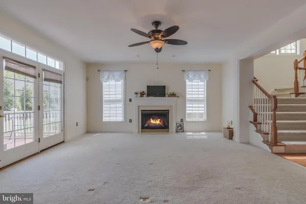 an empty room with windows and a fireplace