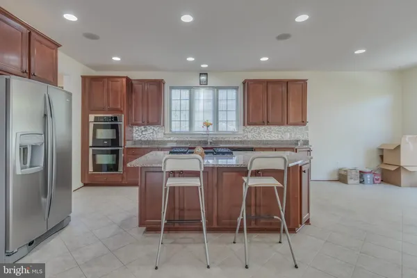 a kitchen with kitchen island granite countertop counter top space a sink stainless steel appliances and cabinets