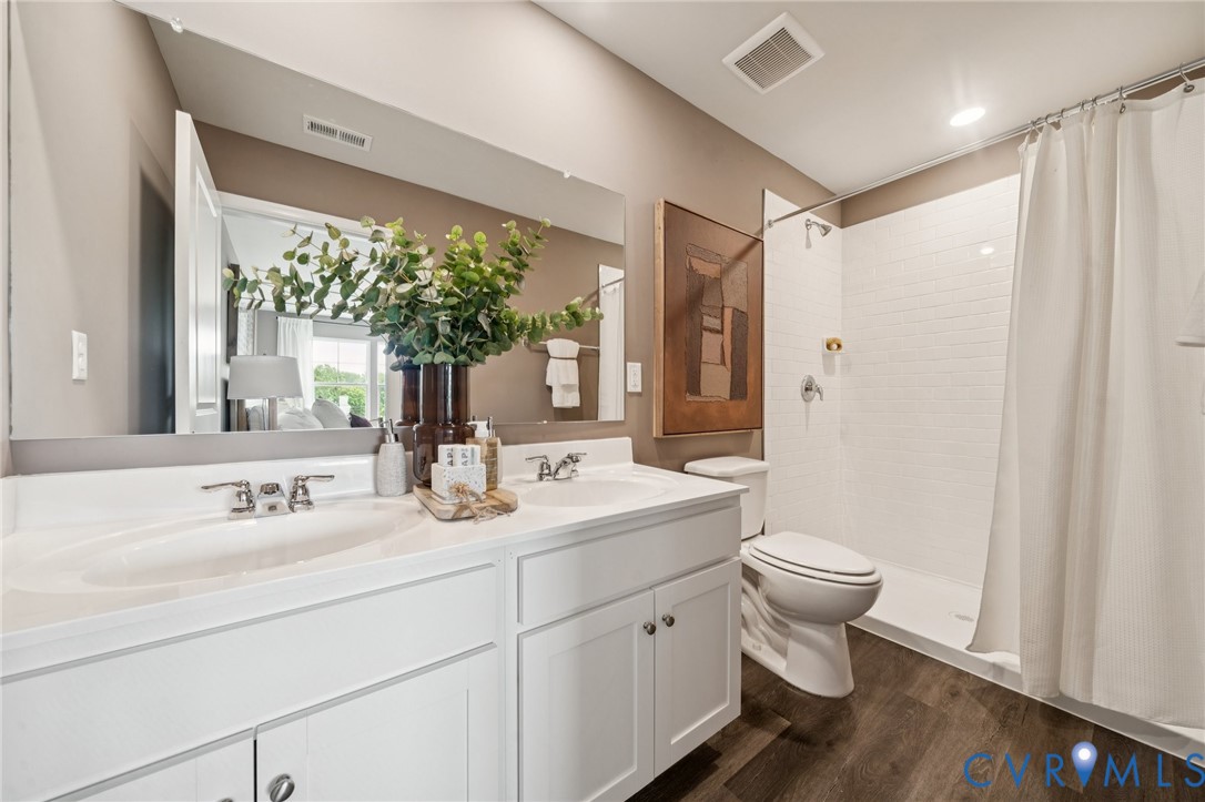 3548 Perrins Hill Way Prince George, VA 23875 - Photo 11 of 17 a bathroom with a toilet a sink and a large mirror