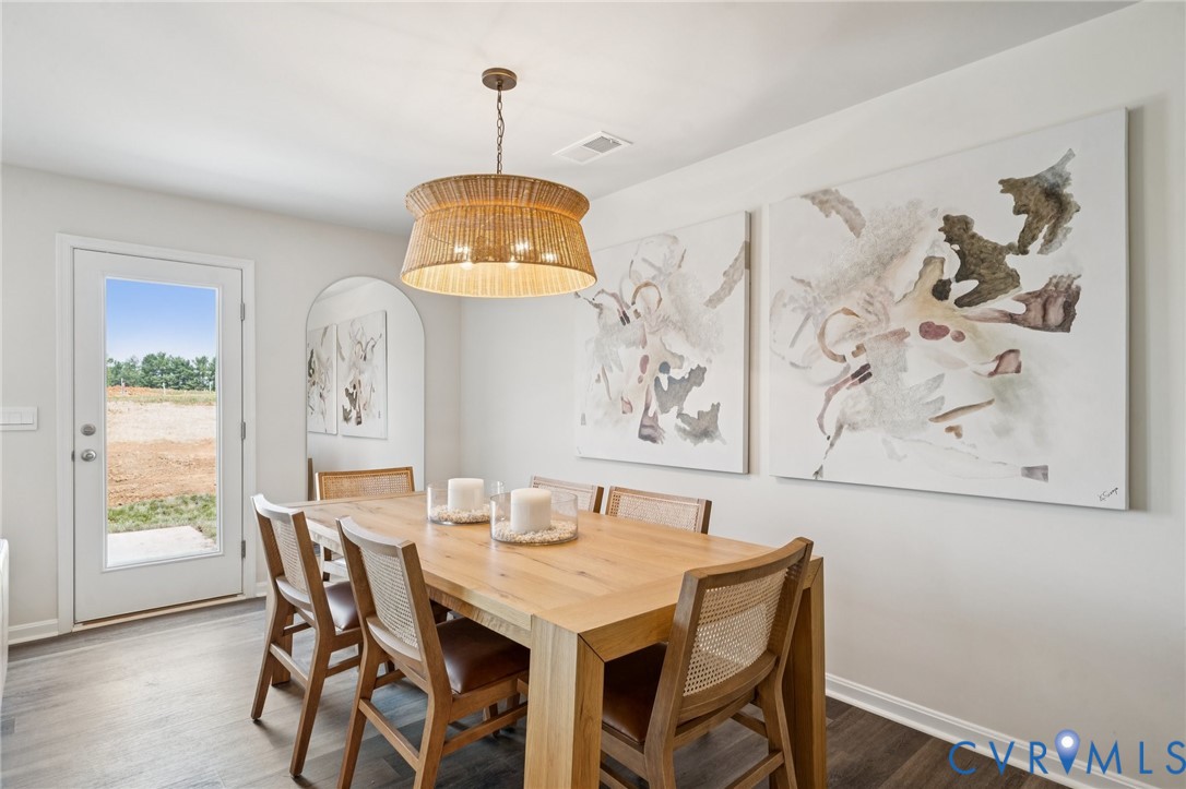 3548 Perrins Hill Way Prince George, VA 23875 - Photo 6 of 17 a dining room with wooden floor a chandelier a wooden table and chairs