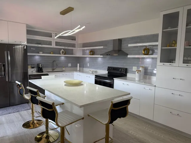 a kitchen with stainless steel appliances kitchen island a table and chairs in it