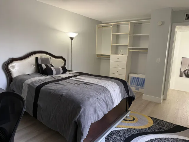 a bedroom with a bed and closet with window