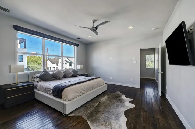 a bedroom with a bed and a flat tv screen on dresser
