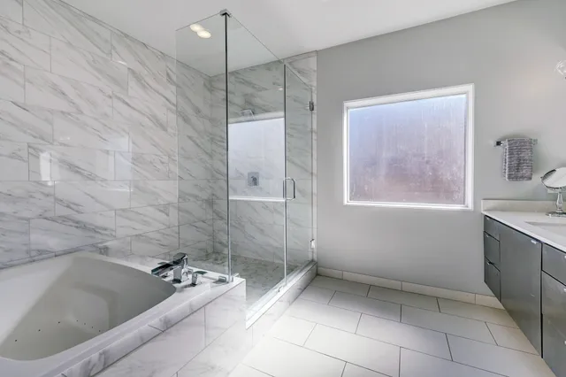 a bathroom with a tub a sink and window