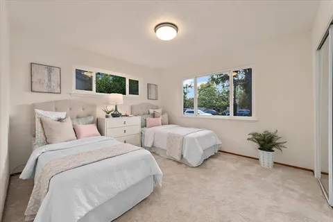 a bedroom with two beds and a potted plant