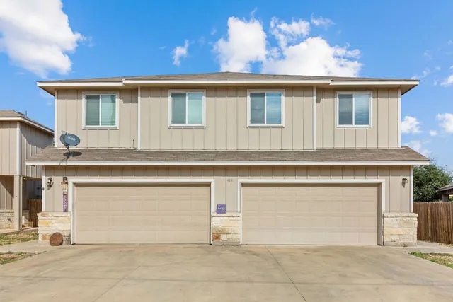 a view of a house with white door and a garage