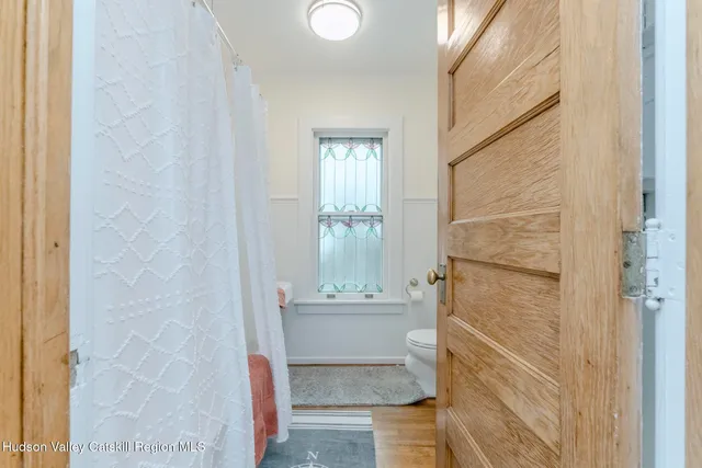 a bathroom with a toilet and a shower curtain