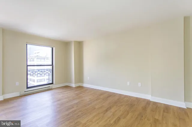 an empty room with wooden floor and window