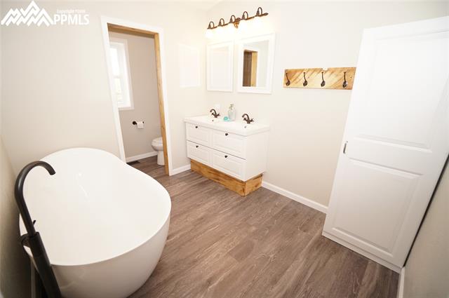13745 Woodlake Road Elbert, CO 80106 - Photo 14 of 36 Remodeled master bathroom with slipper tub and vinyl plank flooring.