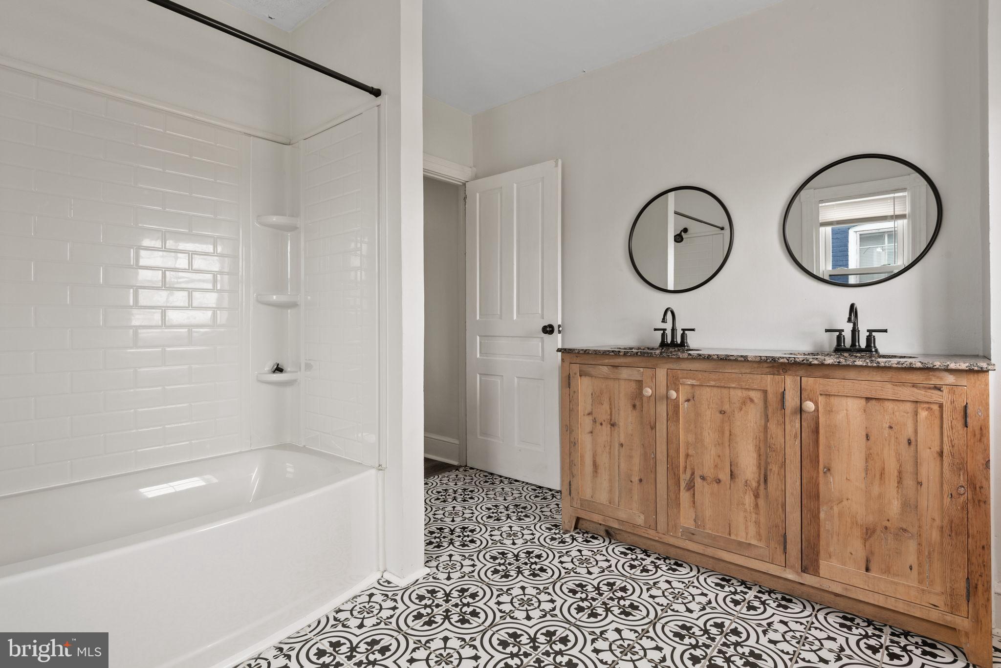245 Jackson Street Lancaster, PA 17603 - Photo 25 of 38 a bathroom with a tub a sink and a large mirror