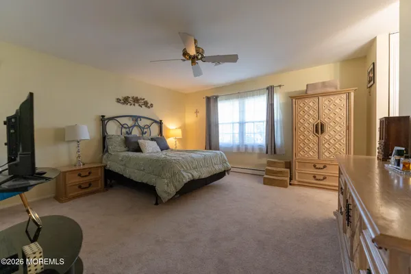 a bedroom with a bed flat screen tv and windows