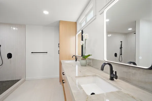 a bathroom with a sink a tub and a mirror