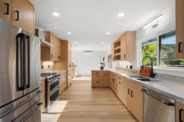 a large kitchen with stainless steel appliances lots of counter space and window