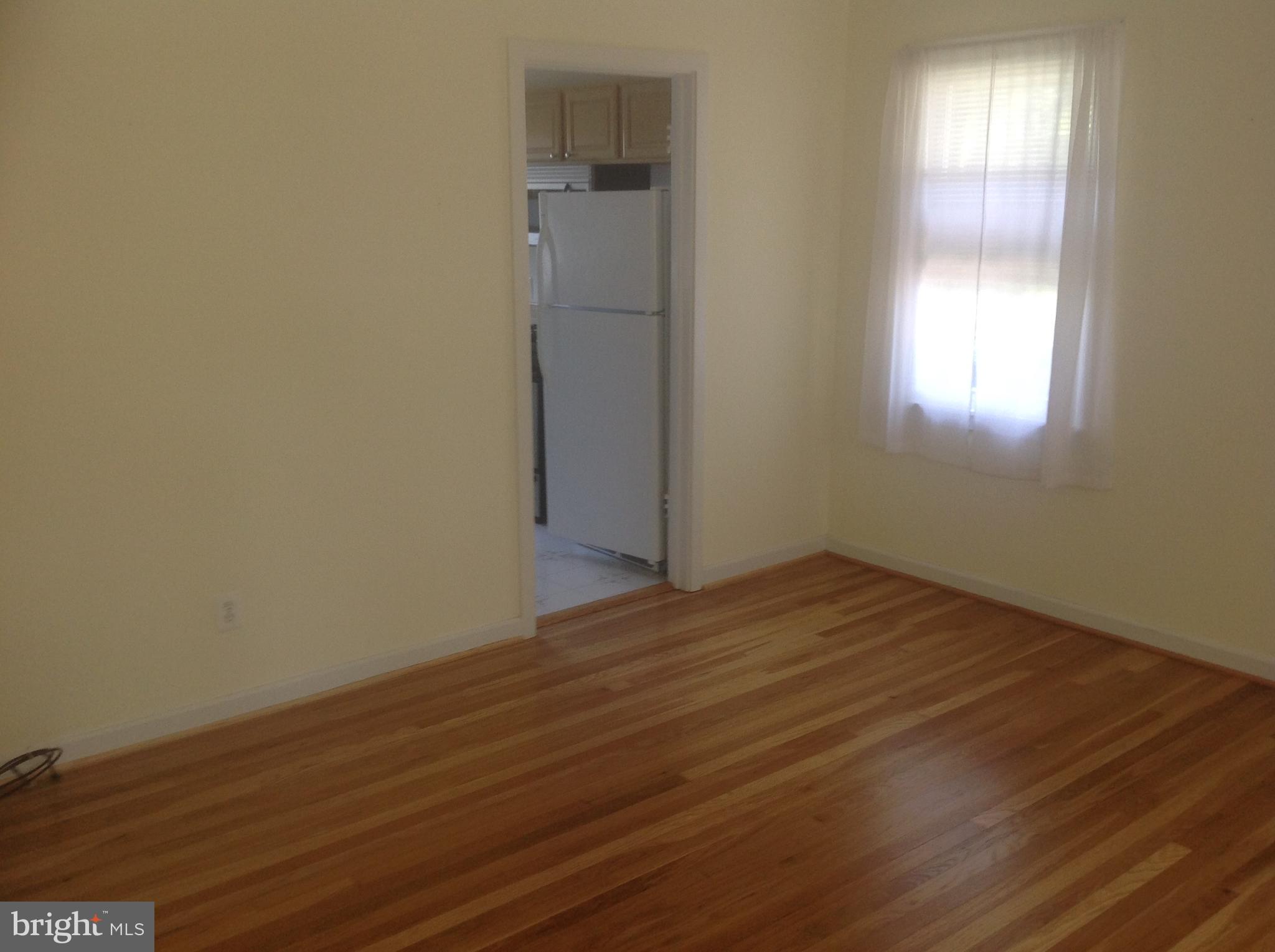1205 Highwood Road Rockville, MD 20851 - Photo 7 of 12 an empty room with wooden floor and windows