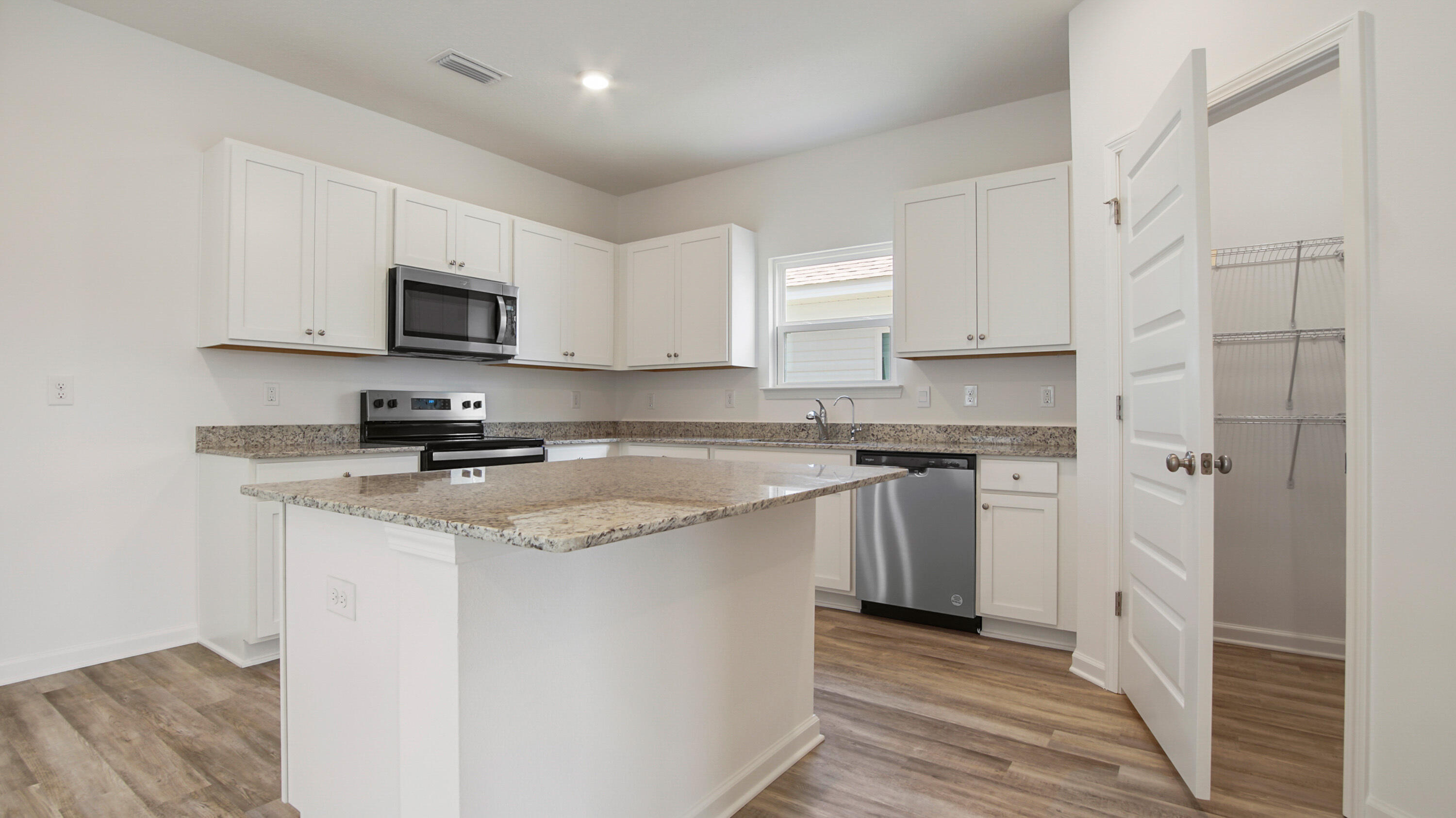 73 Huckleberry Street Freeport, FL 32439 - Photo 11 of 34 a kitchen with stainless steel appliances granite countertop a stove a sink and a microwave
