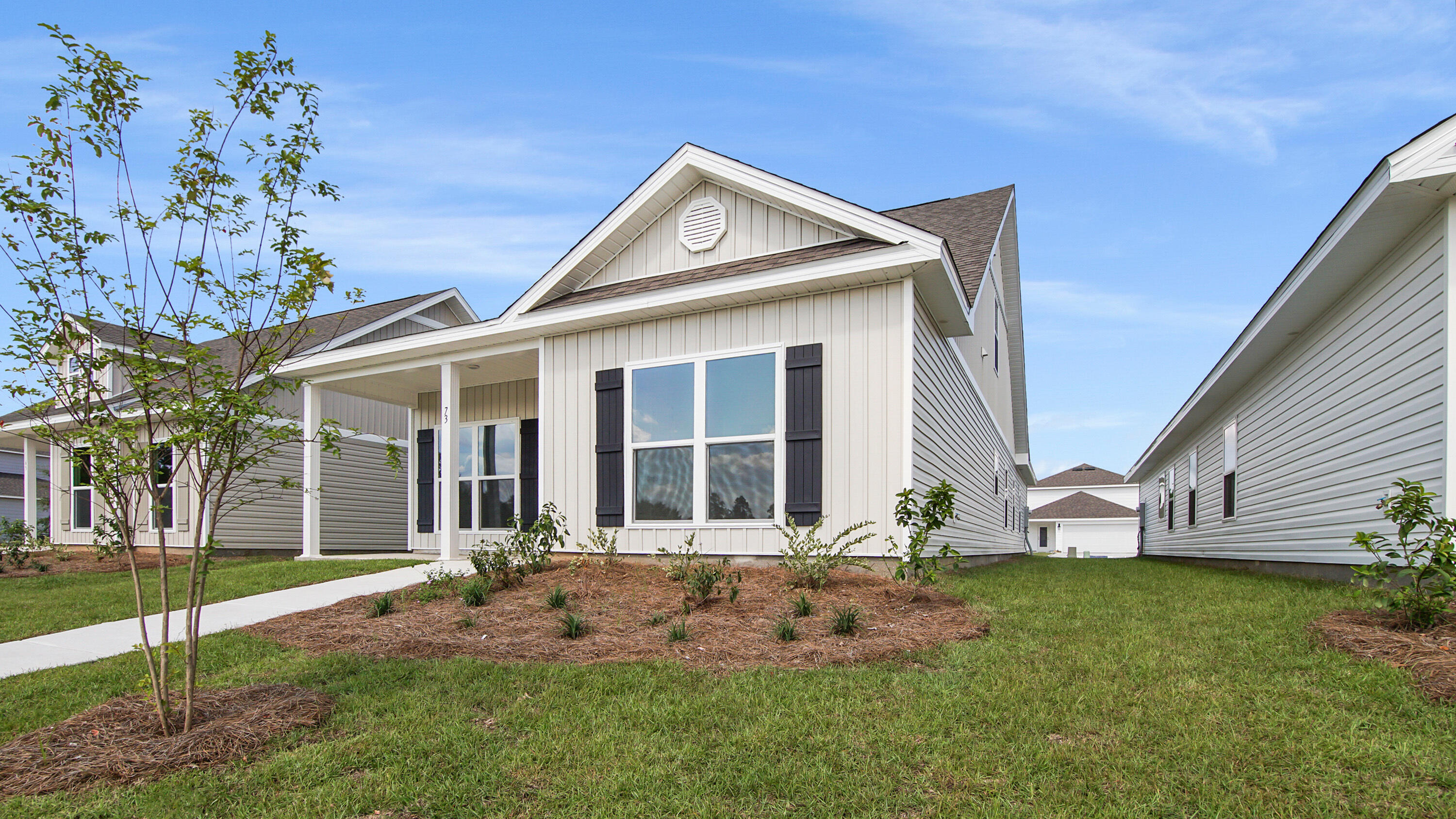 73 Huckleberry Street Freeport, FL 32439 - Photo 2 of 34 a front view of a house with a yard and garage