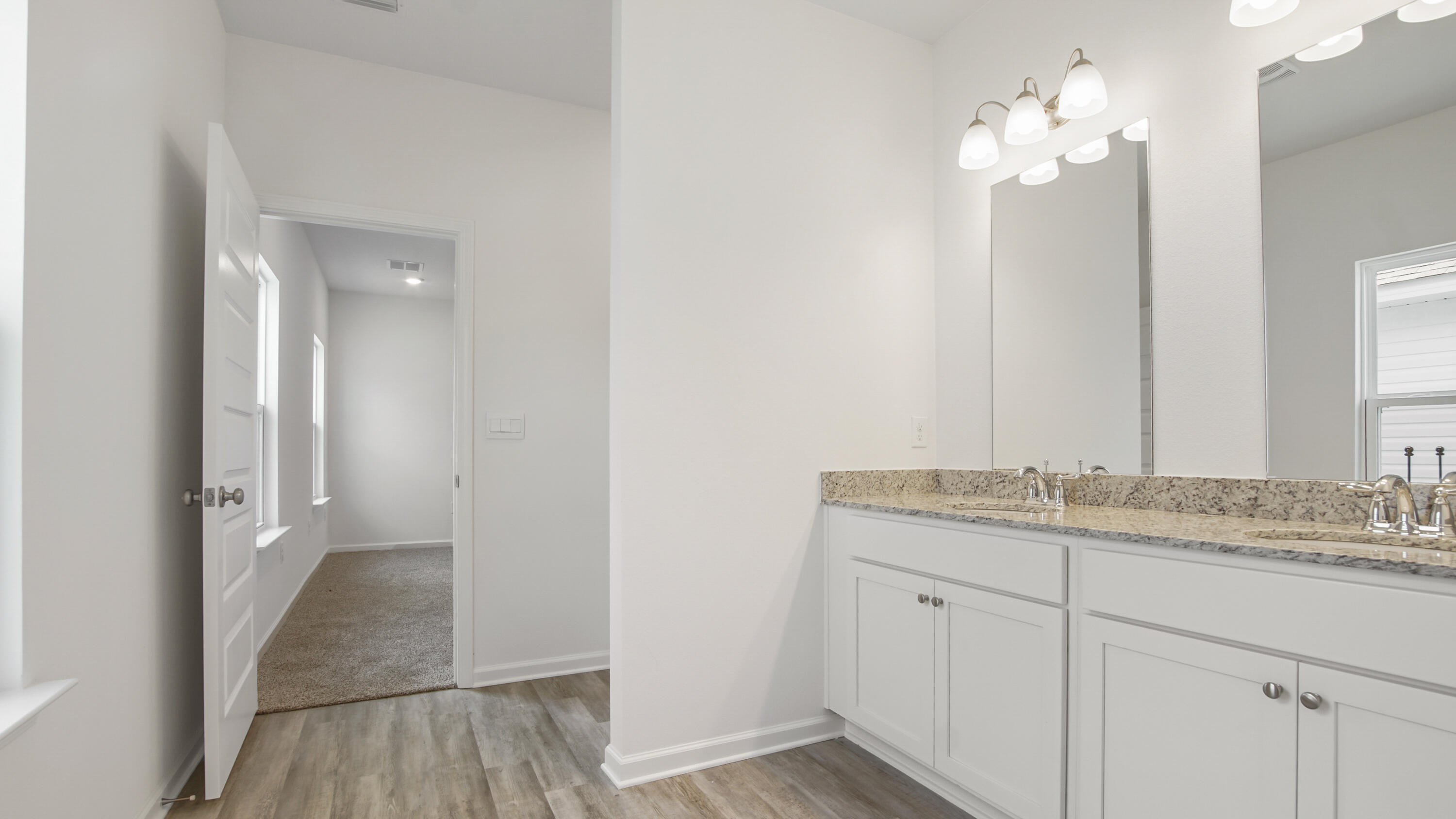 73 Huckleberry Street Freeport, FL 32439 - Photo 23 of 34 a bathroom with a granite countertop sink a light fixture and a mirror