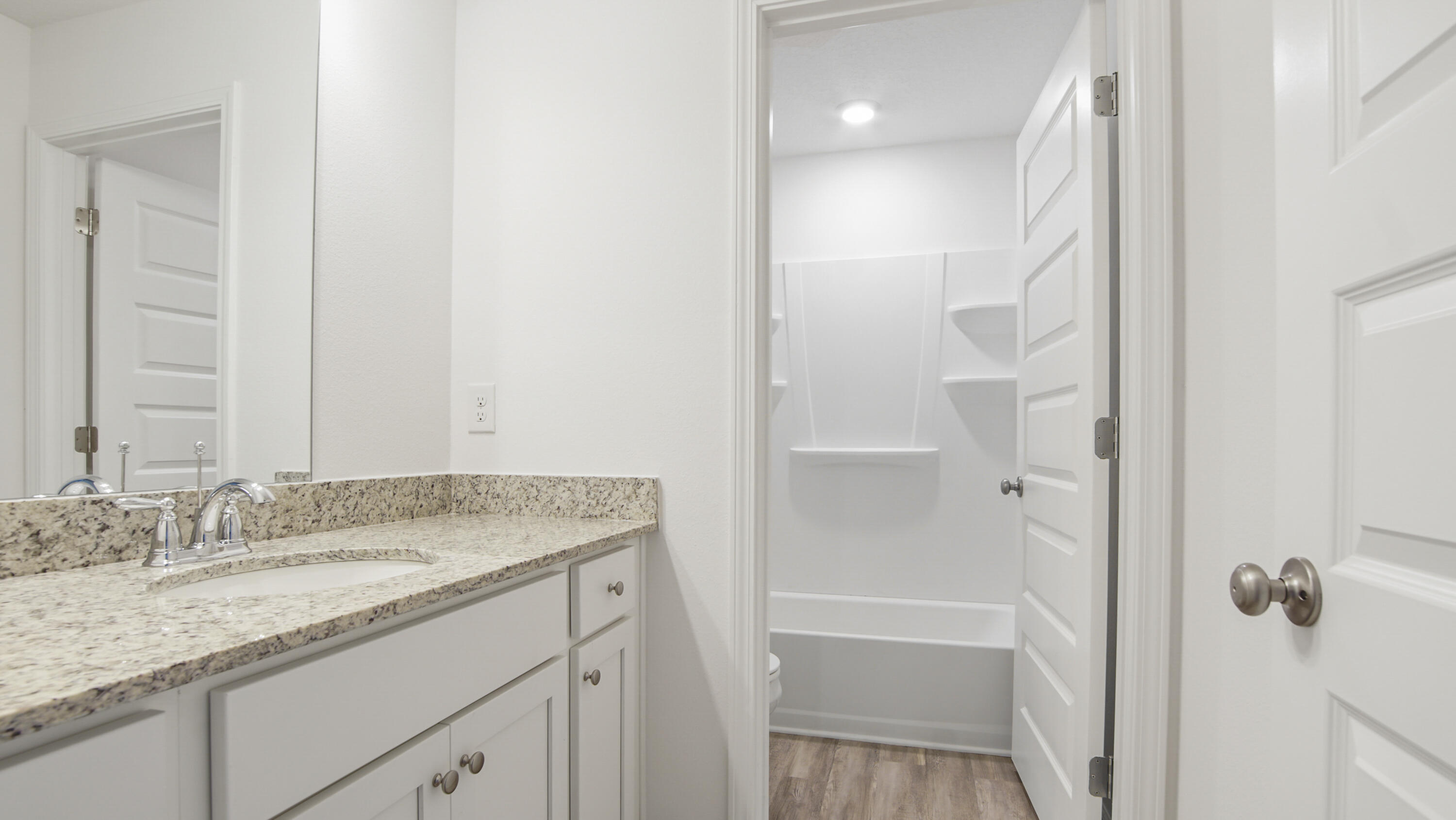 73 Huckleberry Street Freeport, FL 32439 - Photo 26 of 34 a bathroom with a granite countertop sink a mirror and a shower