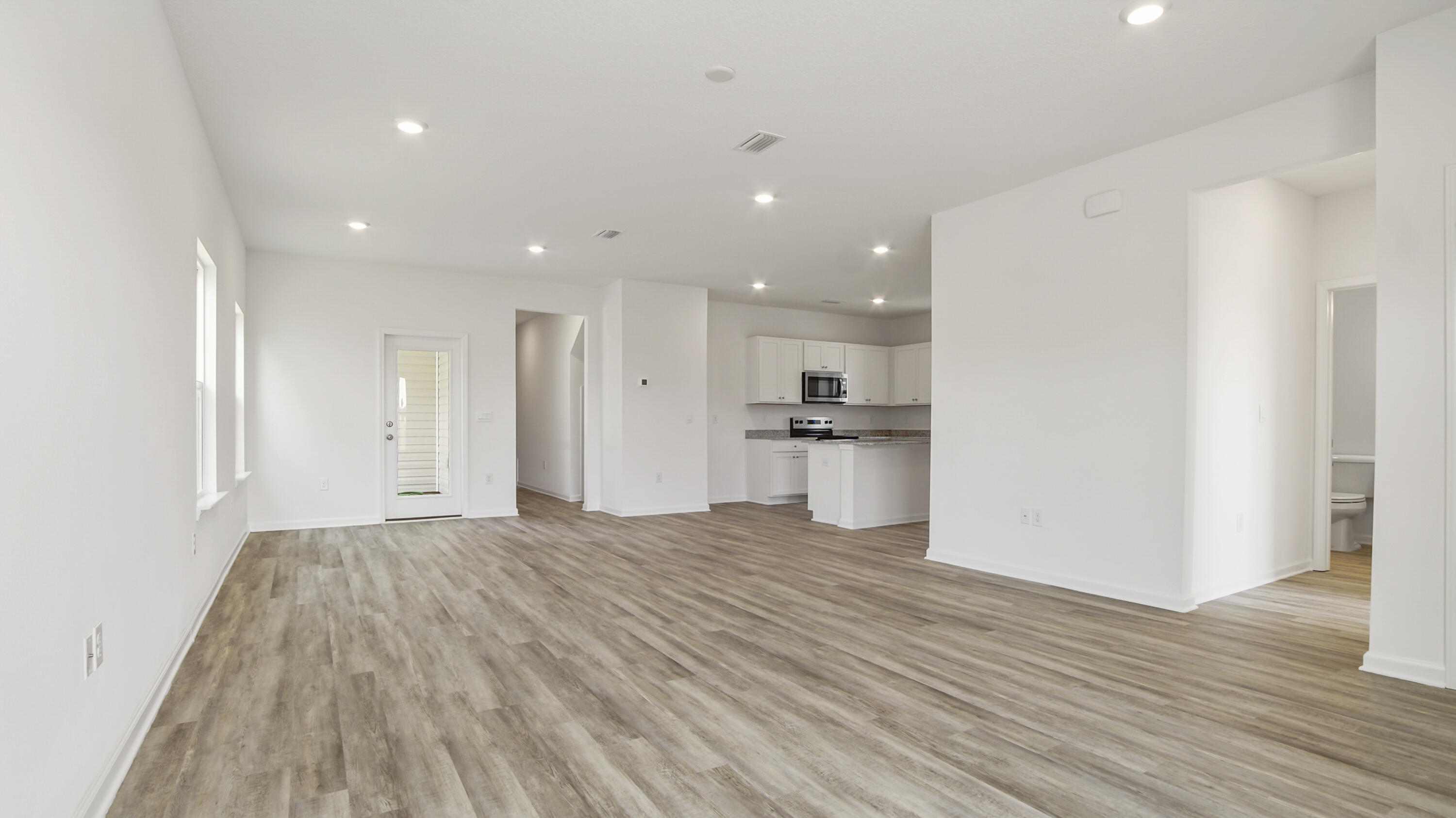 73 Huckleberry Street Freeport, FL 32439 - Photo 5 of 34 a view of kitchen with refrigerator stove and wooden floor