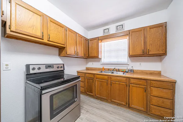 a kitchen with stainless steel appliances granite countertop a sink a stove and cabinets