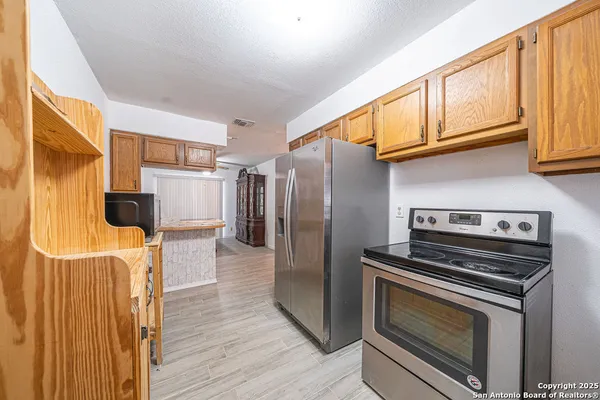 a kitchen with stainless steel appliances a stove a microwave and a refrigerator