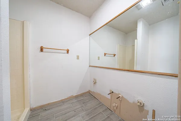 a bathroom with a granite countertop toilet and a shower