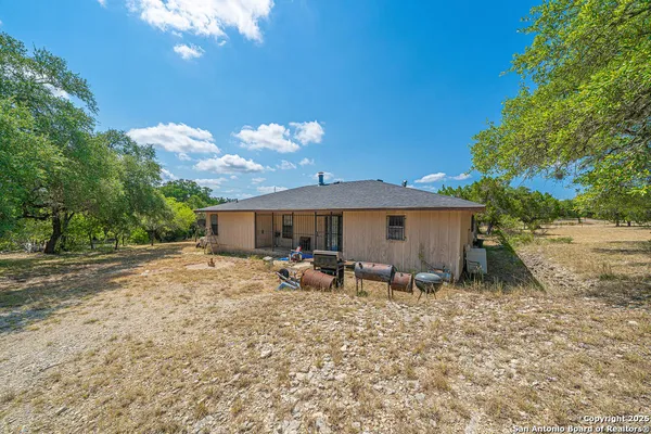 a view of a house with backyard and a tree