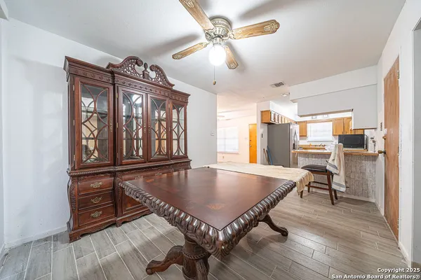 a dining room with wooden floor a chandelier a wooden table and chairs