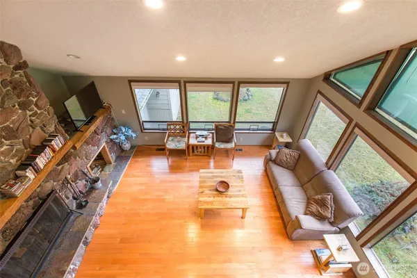 a living room with furniture fireplace and large windows