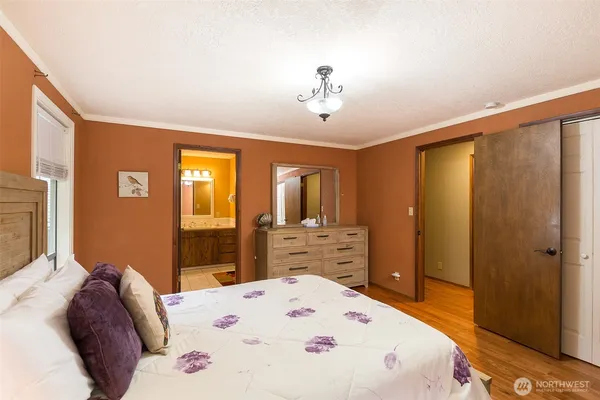 a bedroom with a bed dresser and a large mirror