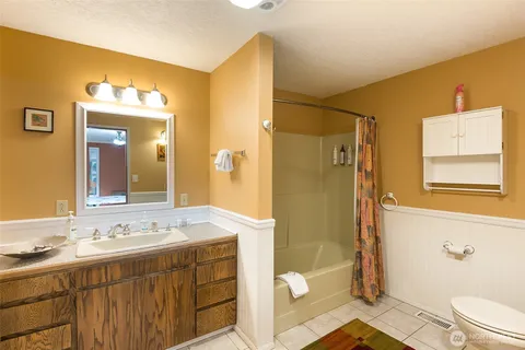 a bathroom with a granite countertop sink toilet and shower