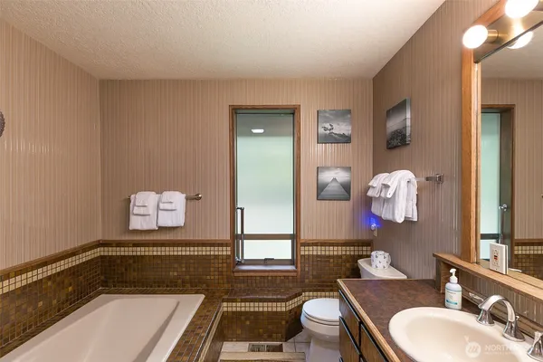 a bathroom with a tub sink and mirror
