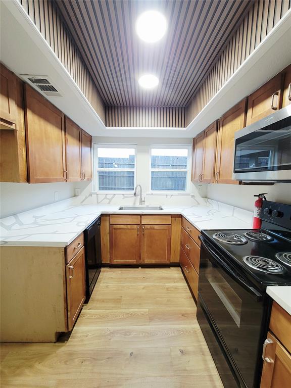 735 Arrowhead Circle Garland, TX 75043 - Photo 9 of 20 a kitchen with stainless steel appliances granite countertop wooden cabinets a sink dishwasher a stove and a refrigerator with wooden floor