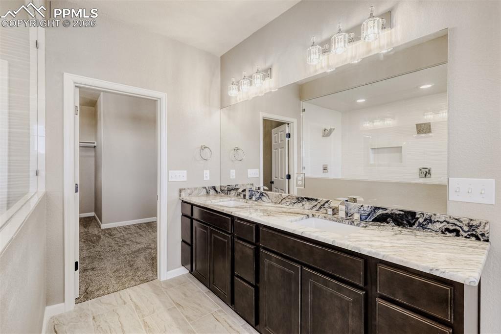 13680 Woodlake Road Elbert, CO 80106 - Photo 16 of 38 a spacious bathroom with a granite countertop sink a mirror and a shower