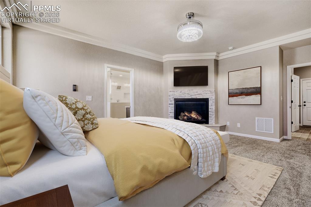 13680 Woodlake Road Elbert, CO 80106 - Photo 20 of 47 a spacious bedroom with a bed and a fireplace