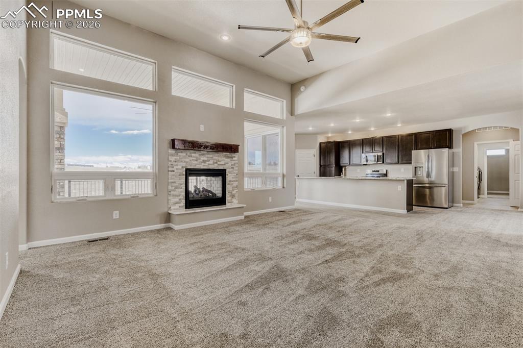 13680 Woodlake Road Elbert, CO 80106 - Photo 6 of 38 a view of a livingroom with a fireplace a ceiling fan and windows
