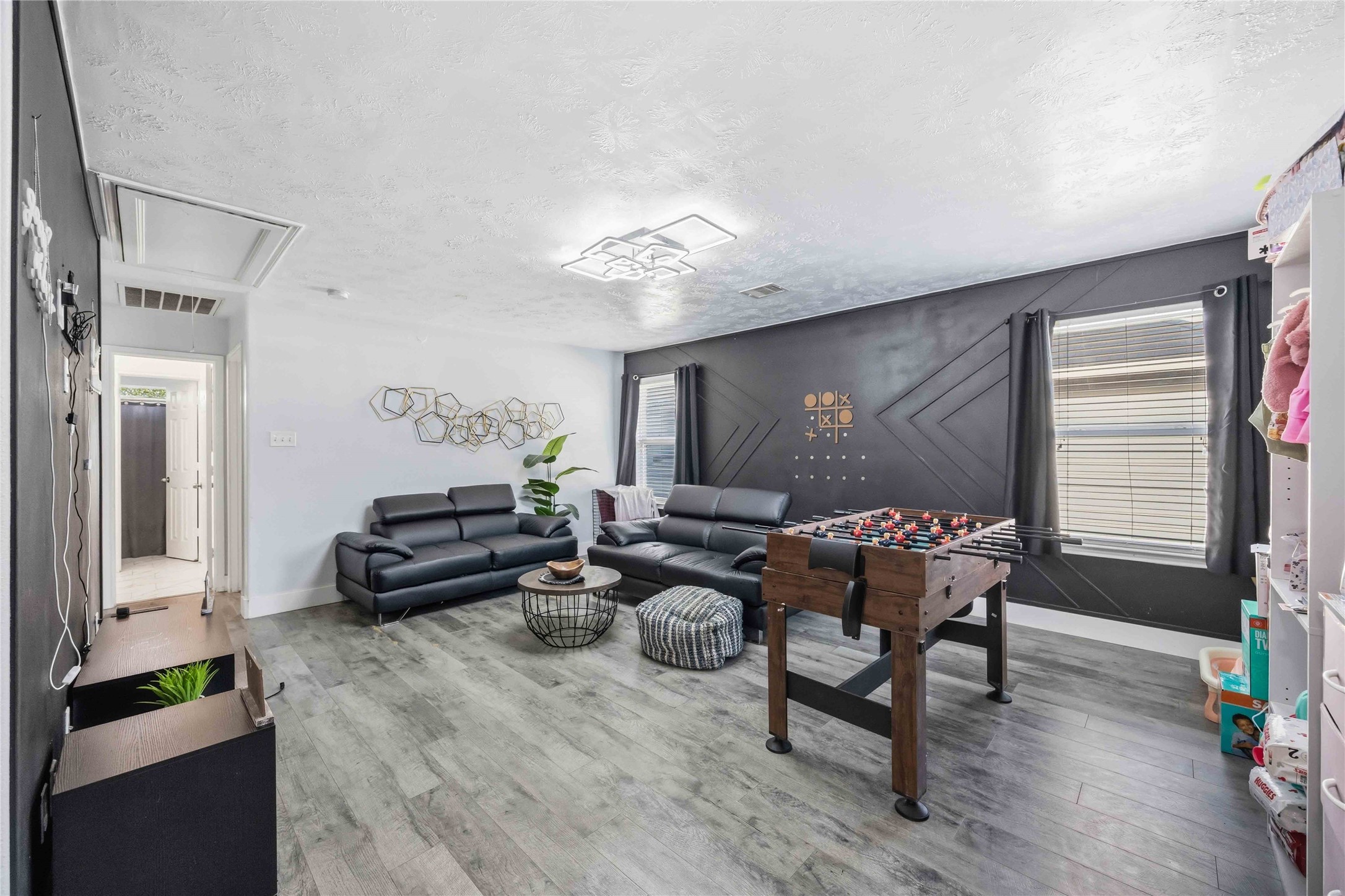 3538 Maris Way Humble, TX 77338 - Photo 11 of 24 Versatile flex space featuring durable wood-look flooring, neutral paint tones, and ample room for multiple uses. The layout easily accommodates a secondary living area, game or recreation space, home office, or media room. Large windows bring in natural light, while the open design offers flexibility to suit a variety of lifestyle needs.