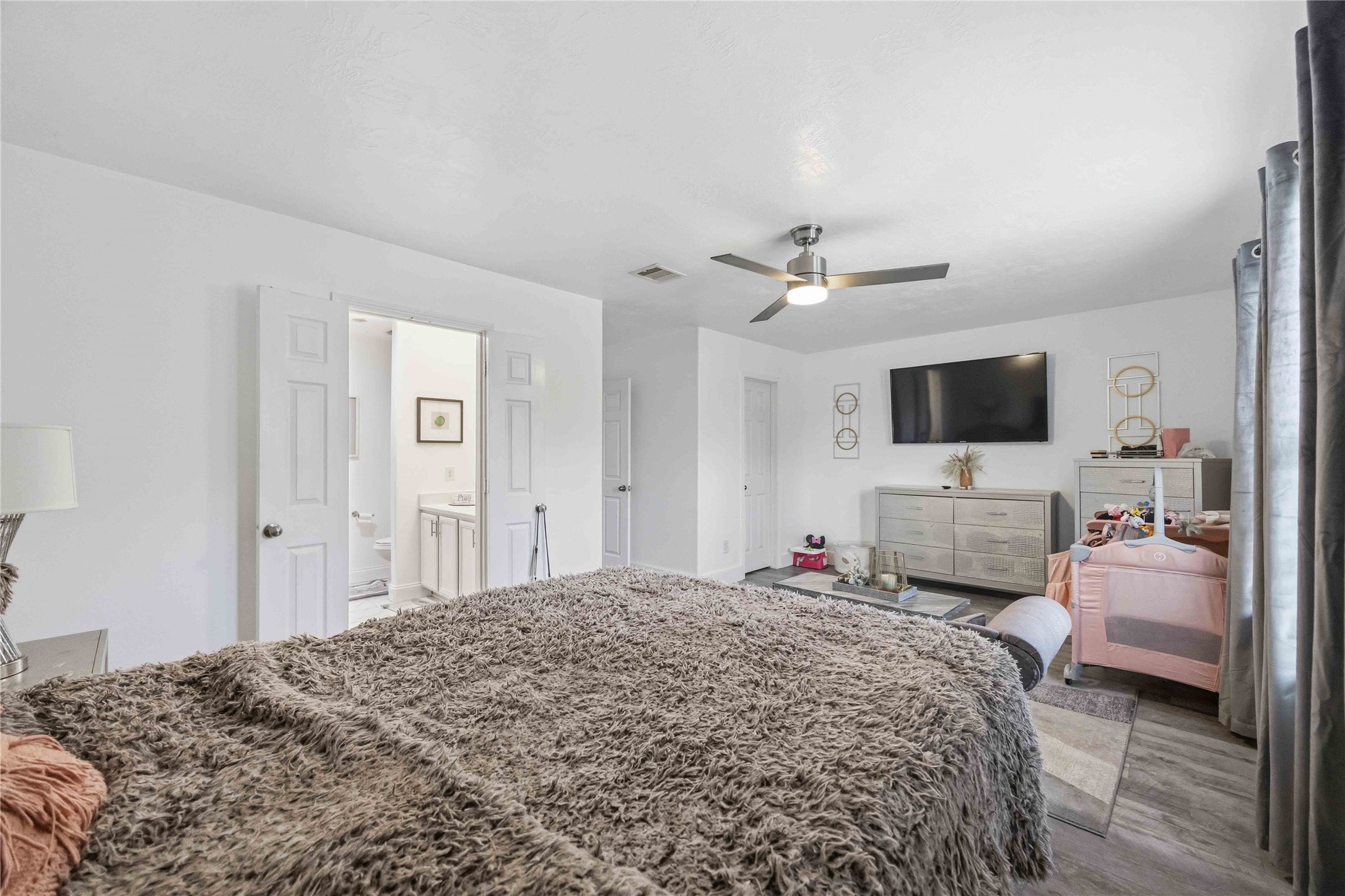 3538 Maris Way Humble, TX 77338 - Photo 15 of 24 Generously sized primary bedroom featuring wood-look flooring, ceiling fan, and abundant natural light. Comfortable layout offers space for a full bedroom set plus seating, creating a relaxing private retreat.