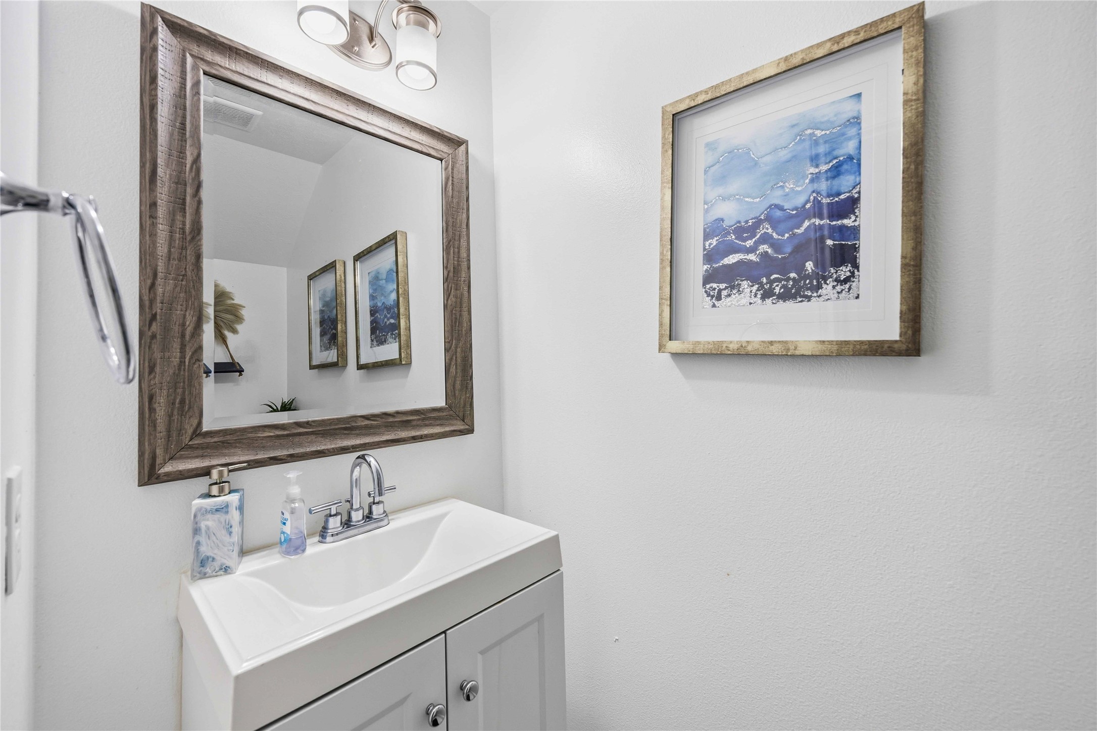 3538 Maris Way Humble, TX 77338 - Photo 20 of 24 Stylish half bath featuring a modern vanity, sleek sink, and framed mirror with updated lighting. Neutral tones and clean finishes create a bright, inviting space for guests.