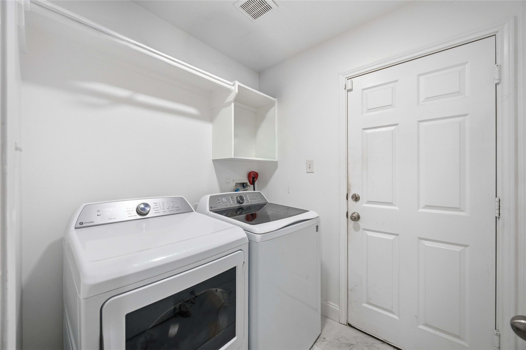 3538 Maris Way Humble, TX 77338 - Photo 21 of 24 Dedicated laundry room featuring full-size washer and dryer connections, built-in shelving, and a private exterior door for added convenience and functionality.