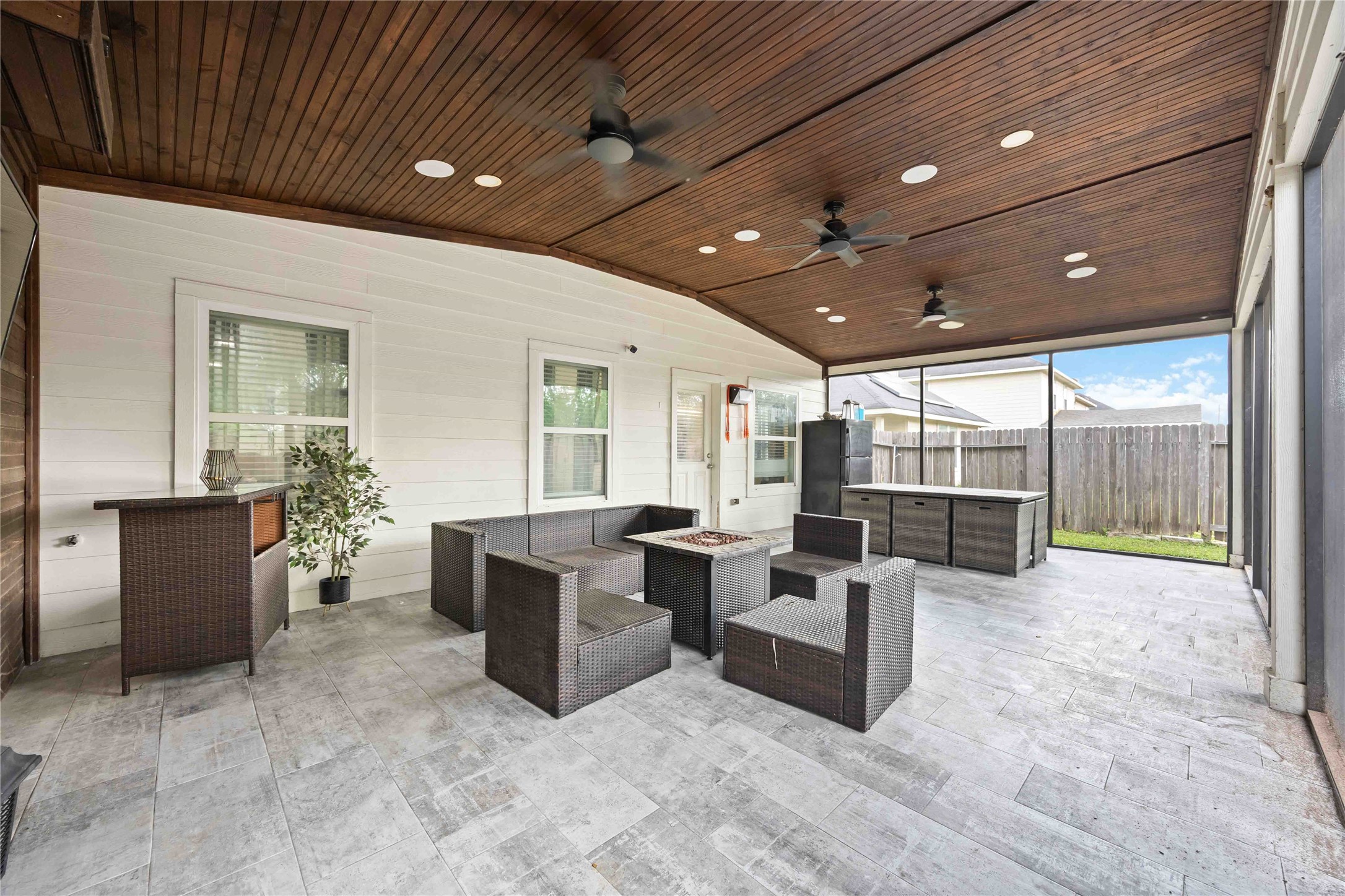 3538 Maris Way Humble, TX 77338 - Photo 23 of 24 Spacious covered patio featuring a wood-plank ceiling, recessed lighting, and ceiling fans for year-round comfort. Outdoor seating area and built-in grill create an ideal space for entertaining and relaxing.
