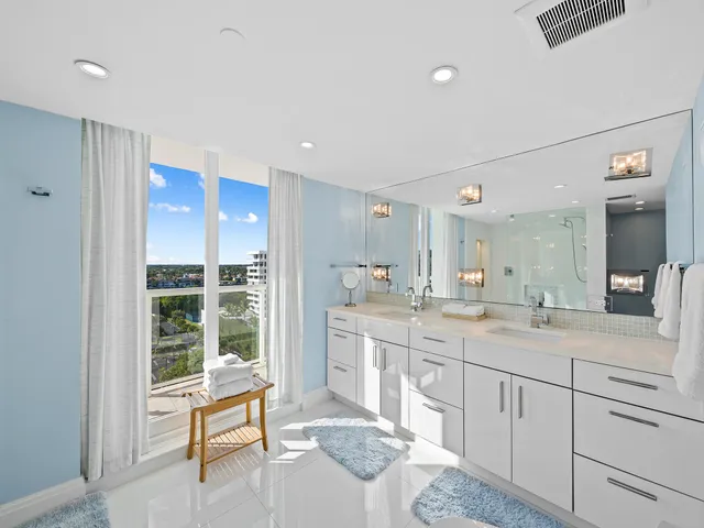 a spacious bathroom with a granite countertop sink a mirror and a shower
