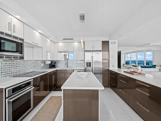 a large kitchen with granite countertop a stove top oven a sink dishwasher a dining table and chairs with wooden cabinets