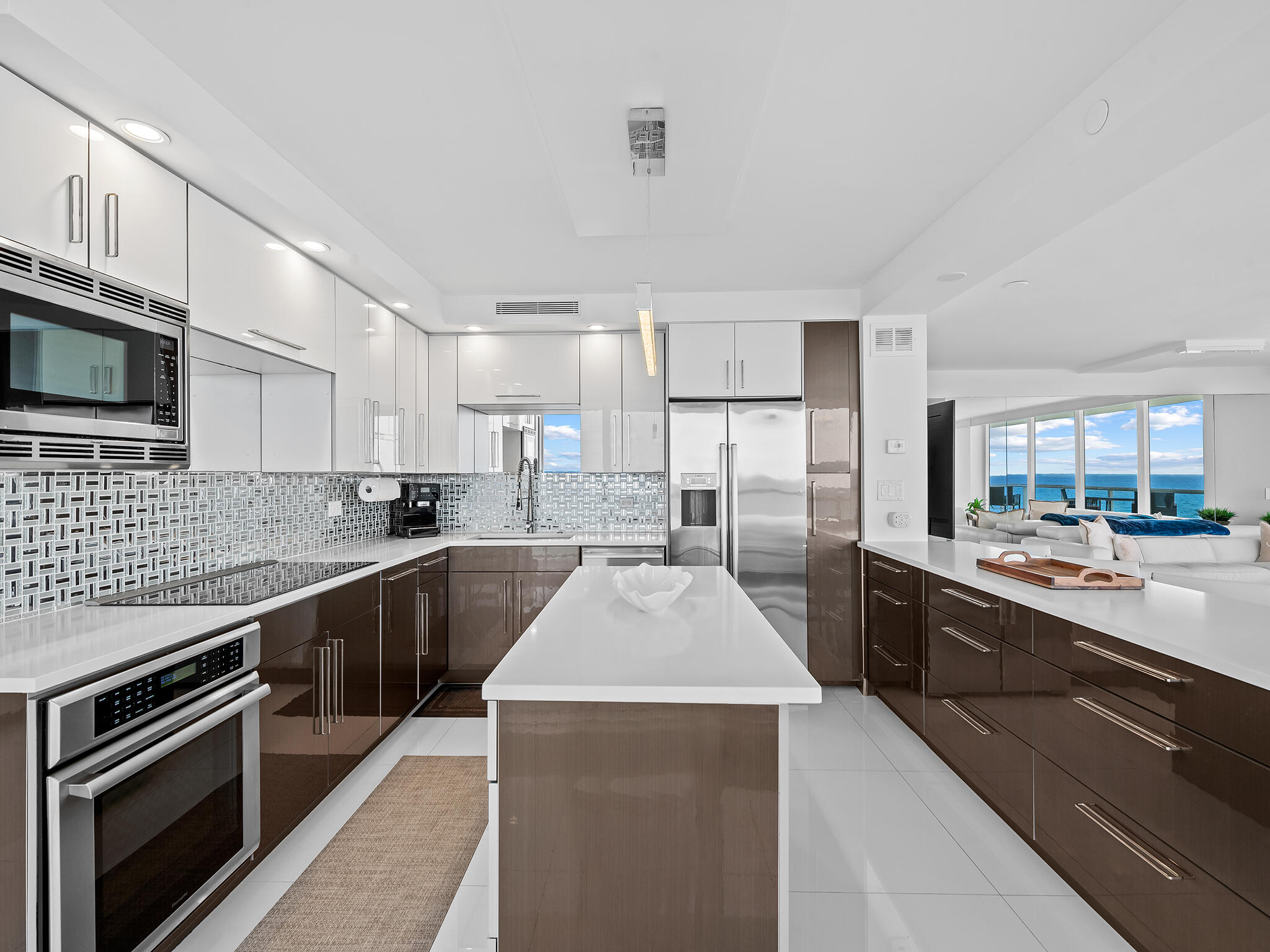 3505 South Ocean Boulevard, Unit 10N Highland Beach, FL 33487 - Photo 4 of 42 a large kitchen with granite countertop a stove top oven a sink dishwasher a dining table and chairs with wooden cabinets