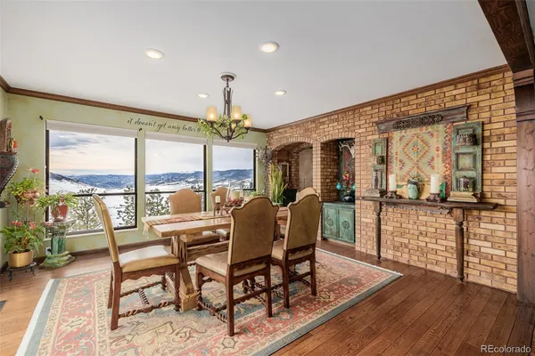 a living room with furniture a large window and wooden floor