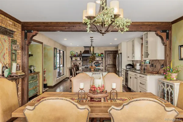 a very nice looking dining room with wooden floor and chandelier