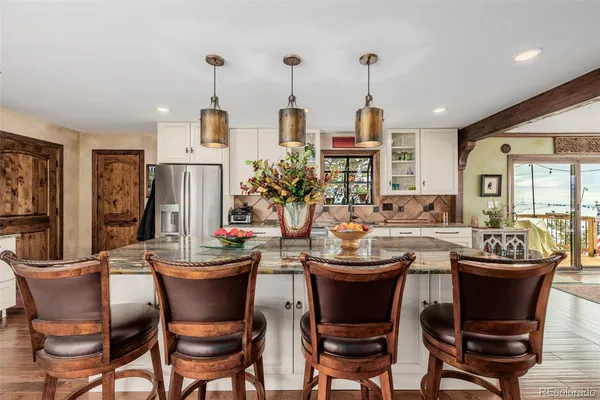 a dining room with chairs a chandelier and wooden floor