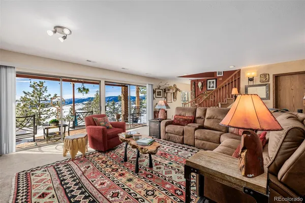 a living room with furniture and a dining table next to a large window