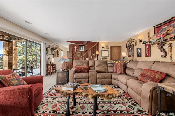 a living room with furniture ceiling fan and a rug